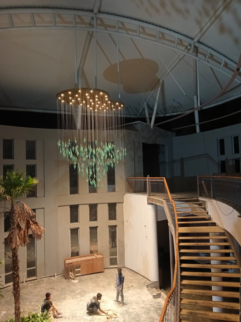 Sculptural chandelier in a tall atrium during installation